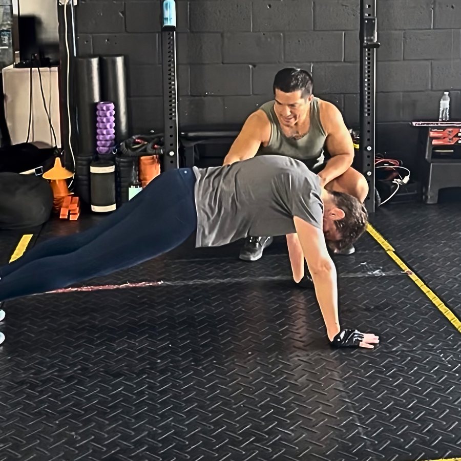 Coach Carlos coaching a member through a movement at Máquina Strength in Palmetto Bay